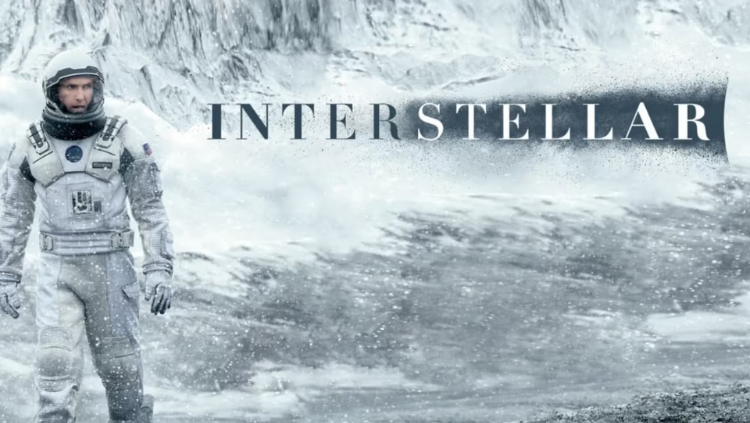 Karakter Joseph Cooper yang diperankan Matthew McConaughey mengenakan baju astronaut NASA putih, berdiri di planet es yang luas dengan latar belakang pegunungan salju dan badai salju, serta tulisan "INTERSTELLAR" di sisi kanan.