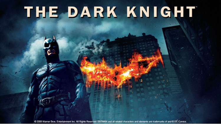 Poster film The Dark Knight menampilkan Batman berdiri tegak di depan gedung yang terbakar dengan simbol kelelawar raksasa dari api, terdapat teks "THE DARK KNIGHT" di bagian atas.