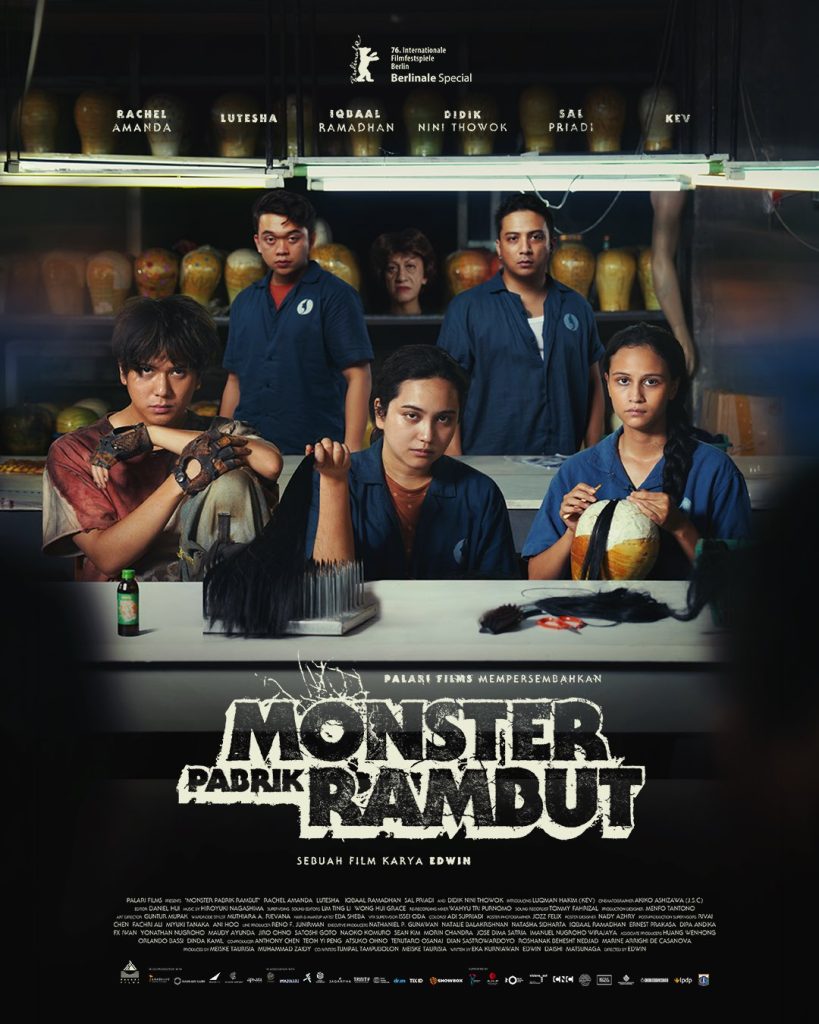 Poster resmi film Monster Pabrik Rambut karya Edwin menampilkan para pemeran utama di sebuah pabrik rambut palsu dengan nuansa horor dan misteri.